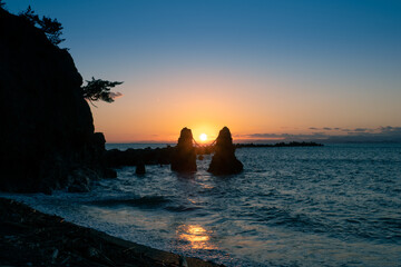 高知県の手結岬、水平線に沈む太陽と夫婦岩