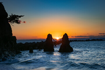 高知県の手結岬、水平線に沈む太陽と夫婦岩