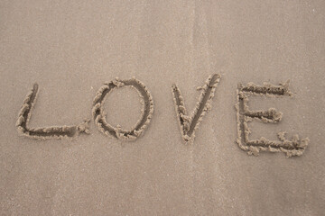 word Love on sand at the beach, concept symbol of valentine day