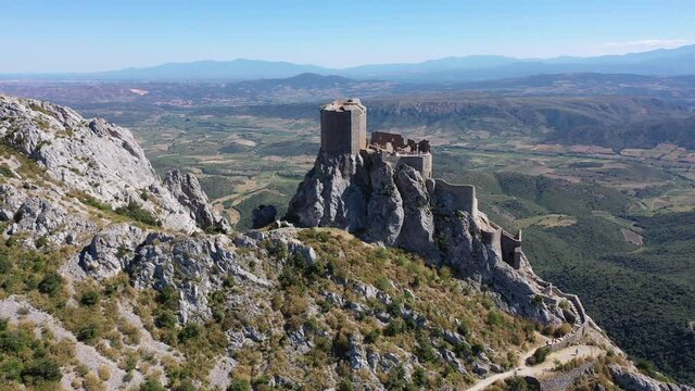 Aerial view of stone ruins of ancient fortified Chateau de Queribus on rocky hilltop on sunny summer day, Aude departement, France