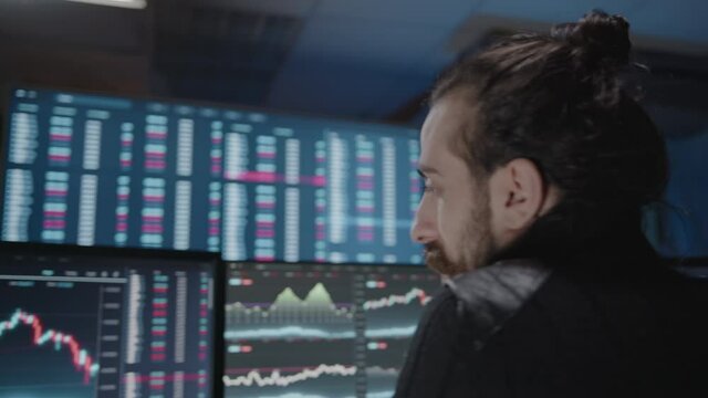 Young nervous professional crypto analyst looking at screens and analyzing for day trading or margin trading, altcoin and bitcoin concept