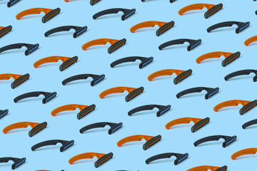 Fototapeta premium Orange and black three-blade safety razors. Seamless repeating pattern.