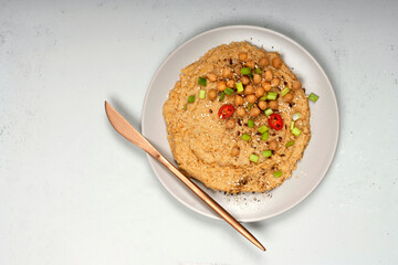 Chickpea hummus isolated on grey plate with bronze knife