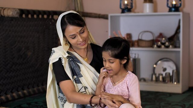 A young girl from an Indian village playing with her mother - Rural India home. A caring female farmer taking care of her daughter - mother-child bonding  love and affection  happy childhood  paren...