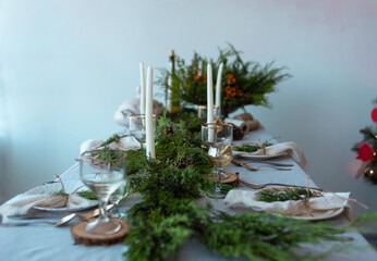 Christmas breakfast, beautiful table setting with Christmas tree decorations in the living room, candles and plates on the festive table in winter