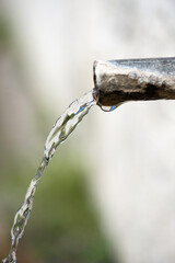 Naklejka na ściany i meble Close-up of a spout at a roadside fountain - selective focus