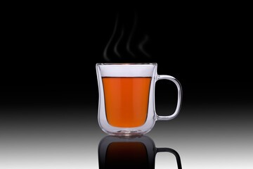 Double glass cup of tea on a black background. Double glass cup isolated. Modern glass tea cup. Steam over a glass cup of tea on the mirror.