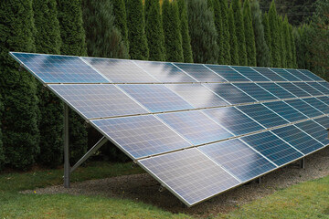 Green electricity. Solar panels standing in the forest. Clean alternative energy. Modern lighting...