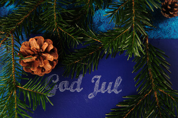 Closeup shot of a Norwegian Christmas greeting, written in chalk on a blue background
