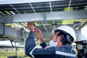 The solar farm(solar panel) with engineers use multimeter check the operation of the system,...