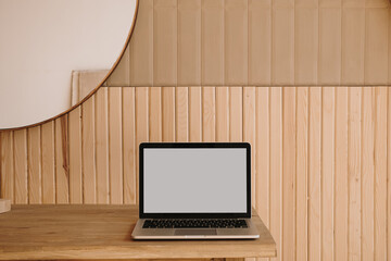 Blank screen laptop on wooden table. Home office desk table workspace. Copy space mockup blog,...