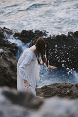 Woman in white dress rocks sea nature