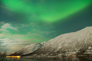 Breathtaking Aurora Borealis over mountain and lake water in Kvaloya, Arctic region in Norway © Marianna Jaszczuk/Wirestock