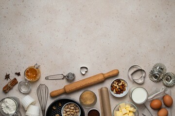 Baking background. Baking tools and food ingredients for baking - flour, eggs, sugar, milk, nuts on beige background. Baking or cooking cakes or muffins. Copy space, top view.