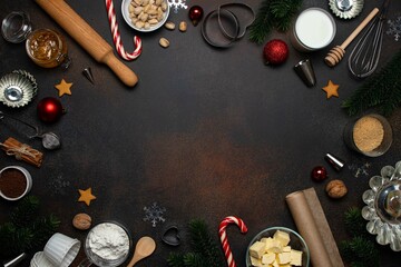 Fototapeta na wymiar Christmas or New Year baking background. Baking tools and food ingredients for baking - flour, eggs, sugar, milk, nuts on dark background. Baking or cooking cakes or muffins. Copy space, top view.