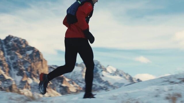 Man running at the mountain with snow