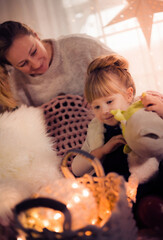 Merry Christmas and Happy Holidays! Mom and daughter decorate the Christmas tree indoors. The morning before Xmas. Portrait loving family close up. - 475972528