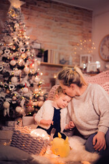 Merry Christmas and Happy Holidays! Mom and daughter decorate the Christmas tree indoors. The morning before Xmas. Portrait loving family close up. - 475972540
