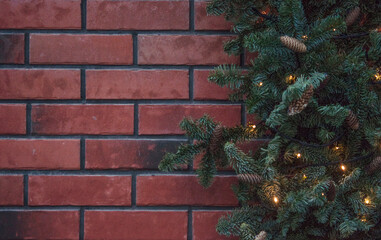 christmas holiday red brick wall and green garland and hanging ball ornaments backdrop background
