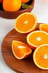 Cut oranges on wooden board on table