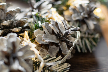 Christmas composition on a wooden background, Christmas cones and balls, green sprigs of needles, yellow lanterns in the form of stars and space for text, beautiful decoration for the home and design