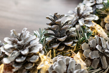 Christmas composition on a wooden background, Christmas cones and balls, green sprigs of needles, yellow lanterns in the form of stars and space for text, beautiful decoration for the home and design