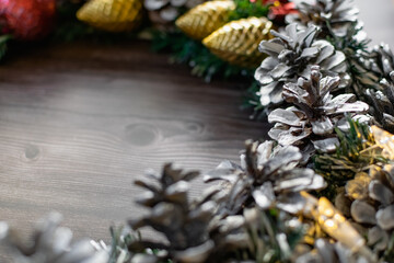 Christmas composition on a wooden background, Christmas cones and balls, green sprigs of needles, yellow lanterns in the form of stars and space for text, beautiful decoration for the home and design