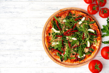 Fresh pizza with herbs and sun dried tomatoes on gray table