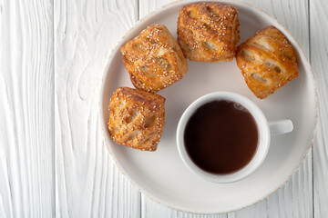 Mug with hot chocolate and sweet puffs on a wooden table