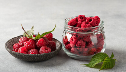 freeze-dried raspberries in a glass jar, fresh raspberries with leaves