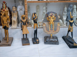 Stone statuettes of Egyptian gods on display in a souvenir shop. Selective focus. Luxor, Egypt.