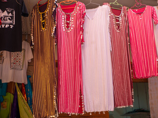 Bright colored dresses decorated in oriental style are sold on display in a clothing store. Luxor,...