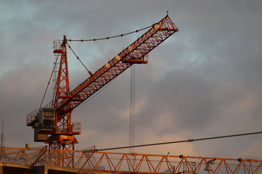 Cinematic image of building crane on unfinished construction.