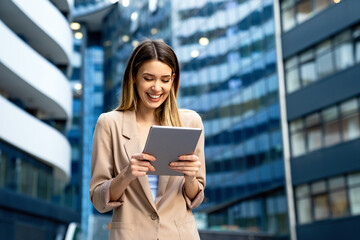 Fototapeta premium Successful businesswoman using a digital tablet while standing in front of business building.
