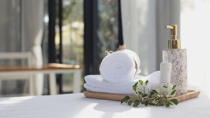 spa concept includes white towels and liquid soap bottles, flowers and aloma fragrance oils Put on an old wooden table And has a natural green background