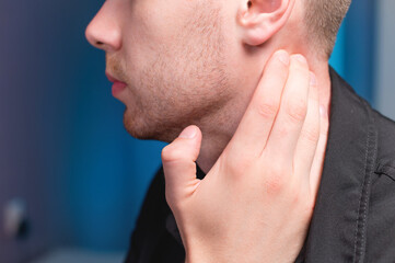 Fototapeta premium Young Caucasian male masseur doing self-neck massage to himself. Close-up. Myofasceal release