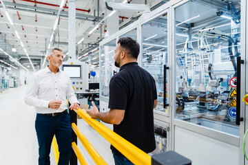 Businessman having discussion with engineer at industrial machinery