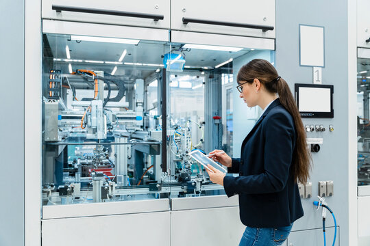 Inspector using tablet PC at industrial machinery