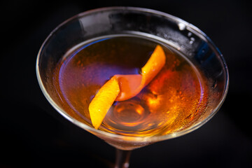 ice cocktail decore with orang peel over dark background