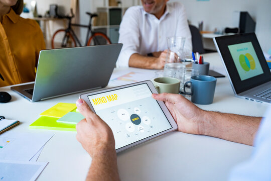 Businessman reading mind map presentation on tablet PC at office