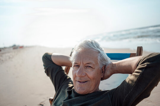 Smiling man relaxing on chair at beach