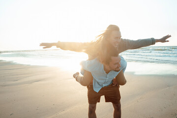 Man piggybacking woman at beach