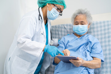 Doctor help Asian senior or elderly old lady woman patient wearing a face mask in hospital for protect safety infection and kill Covid-19 Coronavirus.