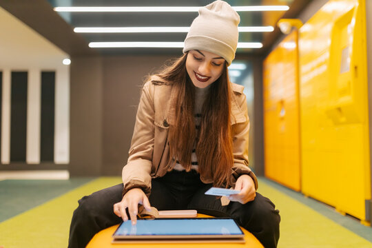 Young Woman Doing Online Payment With Credit Card Using Touch Screen Laptop