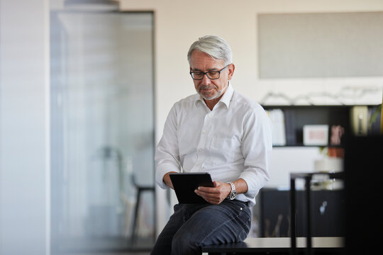 Mature businessman working on tablet PC in office