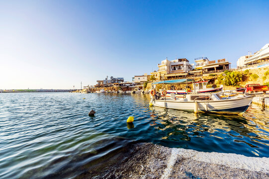 Greece, Crete, Sissi, Edge of coastal village with boat in foreground