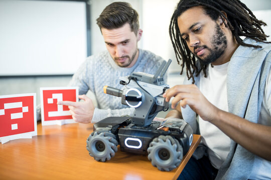 Engineers analyzing robotic combat tank at workshop