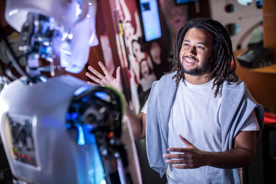 Technician trying to communicate with human robot at workshop