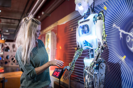 Technician doing handshake with human robot at workshop