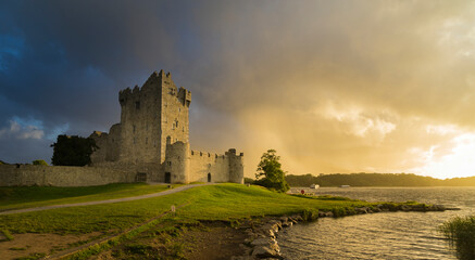 View of the ruins of Ros Castle at sunset under cloudy skies. Medieval castle on the shores of Loch...